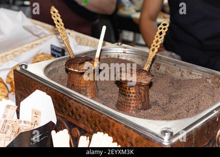 Aromatischer Kaffee in heißem Sand gebrüht - türkischer Kaffee brauen in CEZVE. Stockfoto