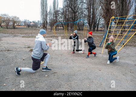 Gruppenkurse im Freien. Organisierte Fitness-Kurse in öffentlichen Parks eingerichtet. Drei Frauen und Männer trainieren gemeinsam im öffentlichen Park. Gesundheit Stockfoto
