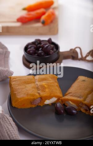 Typisches Gericht von Peru unter dem Namen Tamales bekannt, mit Maismehl, Huhn oder Schweinefleisch, Knoblauch, Chili, schwarzen Oliven und Ei gemacht. Stockfoto