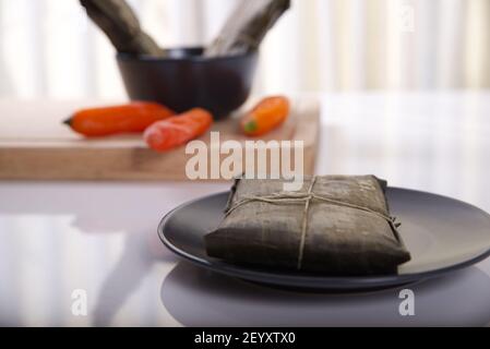 Typisches Gericht von Peru unter dem Namen Tamales bekannt, mit Maismehl, Huhn oder Schweinefleisch, Knoblauch, Chili, schwarzen Oliven und Ei gemacht. Stockfoto