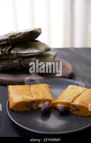 Typisches Gericht von Peru unter dem Namen Tamales bekannt, mit Maismehl, Huhn oder Schweinefleisch, Knoblauch, Chili, schwarzen Oliven und Ei gemacht. Stockfoto