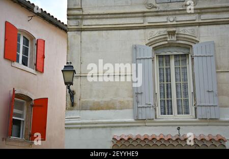 Provençal Haus Marmorfassade mit hellen roten und grauen Holzfensterläden in Saint-Rémy-de-Provence, Bouches-du-Rhône Frankreich. Stockfoto