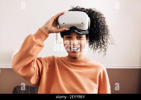 Porträt einer Frau mit gemischter Rasse, die eine VR-Brille hält Stockfoto