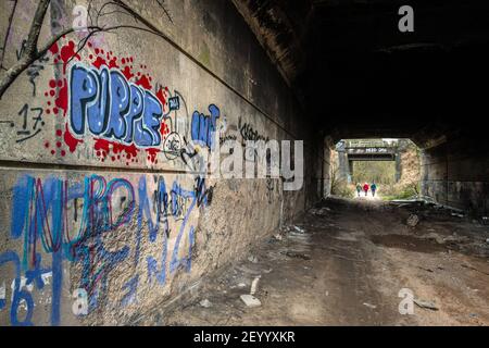 Wand Graffiti und fliegen kippen in einem verlassenen Straßentunnel. Stockfoto