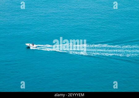 Schnellboot schwimmt schnell auf der Wasseroberfläche und hinterlässt einen Weg auf dem Meer. Stockfoto