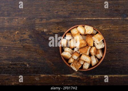 Knusprige Croutons in einer Schüssel auf einem Holzhintergrund. Draufsicht. Stockfoto