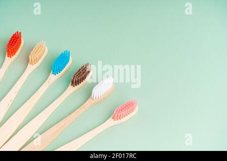 Ein Set umweltfreundlicher antibakterieller Zahnbürsten aus Bambusholz auf hellgrünem Hintergrund. Trends im Bereich Umweltschutz. Stockfoto