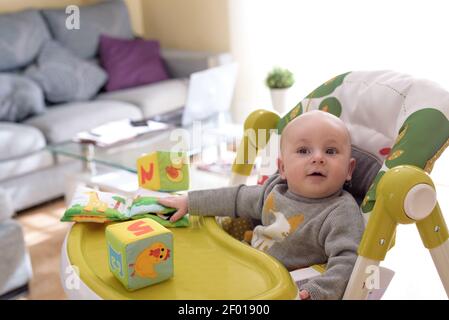 Niedliches kleines Baby spielt mit bunten Blöcken. Stockfoto