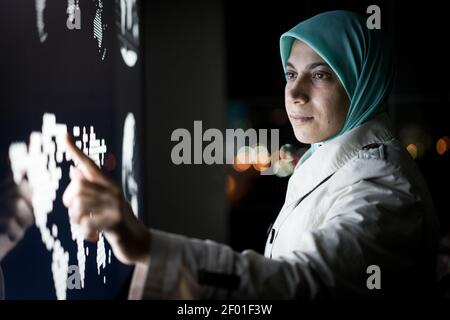 Muslimische Frau arbeitet auf Smart Infografik Bildschirm, hohe Qualität Stockfoto