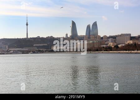 Baku mit den Flame Towers Wolkenkratzern, Fernsehturm und der Küste des Kaspischen Meeres. Blick vom Kaspischen Meer auf den Flame Towers Wolkenkratzer Stockfoto