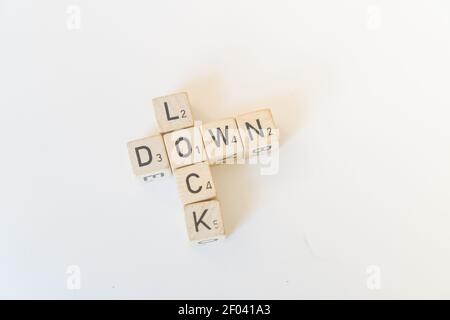 Beschriftet Spiel Holzfliesen oder Würfel buchstabieren Lock Down, das Ergebnis der Pandemie Stockfoto