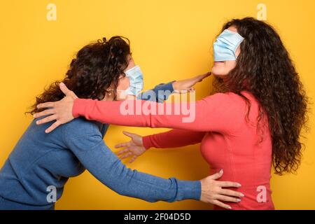 Lustige Freunde sind mit verbundenen Augen mit Gesichtsmaske. Konzept der Verwirrung Stockfoto