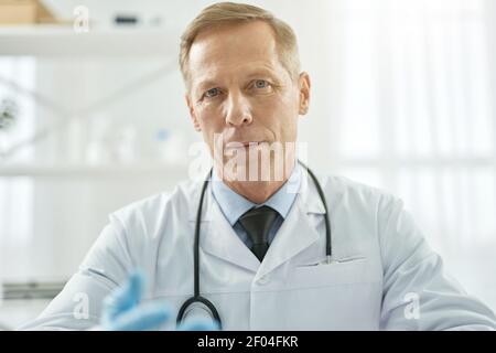 Schöner männlicher Arzt posiert vor weißem Hintergrund Stockfoto