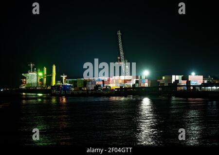 Frachthafen in Stonetown (Tansania, Sansibar Archipel) am Abend und in der Nacht mit Kran und Container. Straßen und Hafen in der alten Steinstadt von Stockfoto