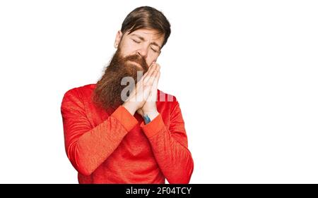 Rotschopf Mann mit langen Bart tragen lässige Kleidung schlafen müde träumen und posieren mit den Händen zusammen, während lächelnd mit geschlossenen Augen. Stockfoto