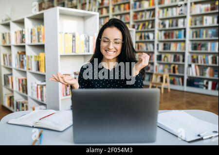 Elegante weibliche Managerin auf Video-Meeting mit Kollegen. Kaukasische schöne Dame kommunizieren mit Kollegen online, lächelnd, mit Laptop Stockfoto