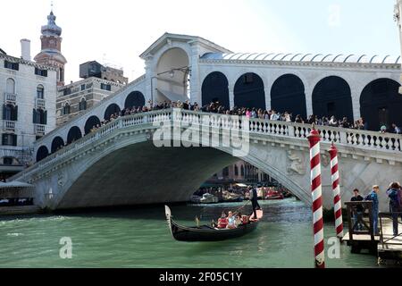 Touristen machen EINE Gondelfahrt unter der Rialtobrücke Der Canal Grande In Venedig Italien Stockfoto