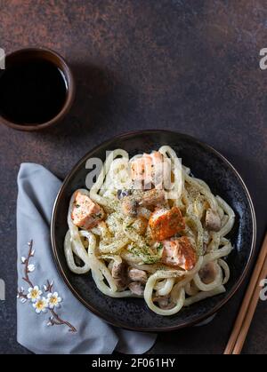 Udon, Weizennudeln, mit Skewered Lachs und Pilzen. Asiatische Küche. Stockfoto