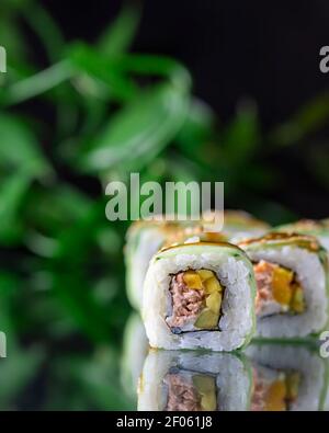 Makro-Ansicht der japanischen Küche Sushi Roll auf Spiegel schwarzen Hintergrund. Speisekarte im Restaurant, Sushi-Bar Stockfoto