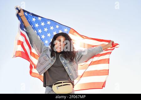 Wütend junge schwarze Frau schreien halten Vereinigte Staaten von Amerika Flagge im Freien. Stockfoto