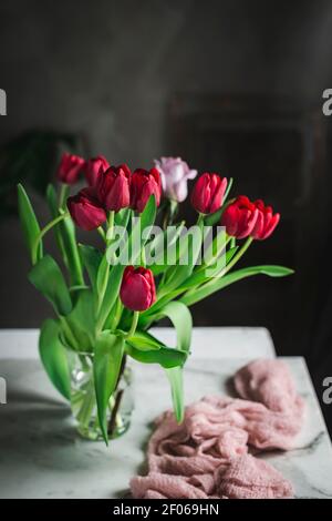 Glasvase mit roten Tulpen auf dem Tisch bei der Angezeigt Stockfoto