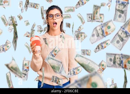 Junge schöne Frau trägt Brille hält Takeaway Tasse Kaffee verängstigt und erstaunt mit offenem Mund für Überraschung, Unglauben Gesicht Stockfoto