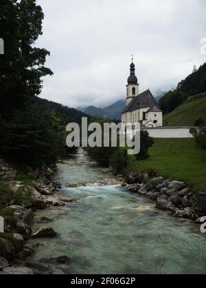 Idyllische ländliche alpine Bergkapelle Pfarrkirche St. Sebastian at Ramsauer Ache in Ramsau Berchtesgaden Oberbayern Deutschland Europa Stockfoto