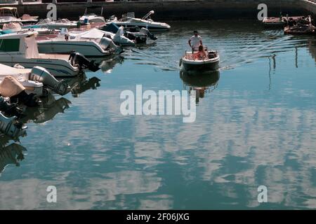 FARO, PORTUGAL - 8. SEPTEMBER 2020: Zwei Personen nutzen ein Boot, um sich auszuruhen und ihren Urlaub im Hafen von Faro, Algarve, an einem Sommertag zu genießen. Stockfoto