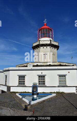 Farol Ponta do Arnel ein Leuchtturm mit einem christlichen Kreuz auf den Azoren. Stockfoto