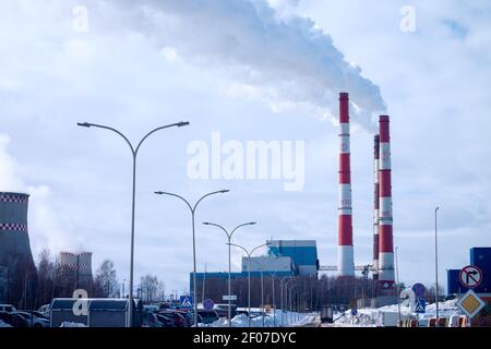 Rauchende Schornsteine der Fabrik auf dem Hintergrund des Himmels mit Wolken In der Stadt Stockfoto