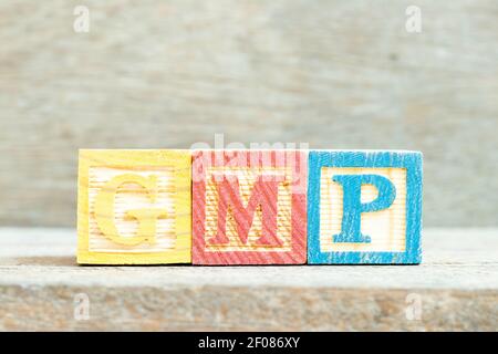 Farbe Alphabet Buchstabenblock in Wort GMP (Abkürzung für Good Manufacturing Practice) auf Holzhintergrund Stockfoto