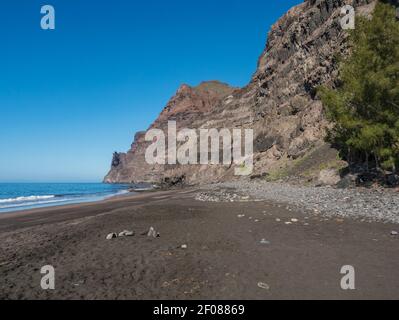 Blick auf den leeren Sandstrand Playa de Guigui mit felsigen Klippen im westlichen Teil der Insel Gran Canaria, nur zu Fuß von Barranco de Guigui erreichbar Stockfoto