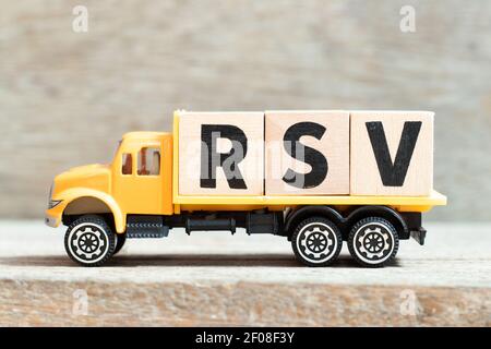 Spielzeug LKW halten Alphabet Buchstaben Block im Wort RSV (Respiratorische Synzytialvirus) auf Holzhintergrund Stockfoto