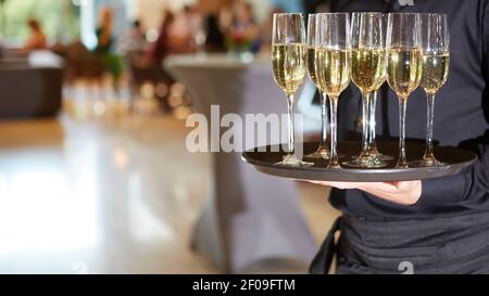 Kellner Champagner auf einem Tablett serviert Stockfoto
