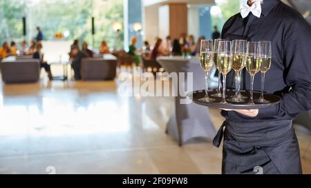 Kellner Champagner auf einem Tablett serviert Stockfoto
