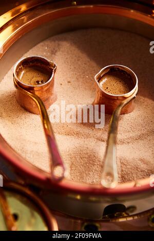 Zubereitung von türkischem Kaffee in die Cezve im Sand Café-bar Stockfoto