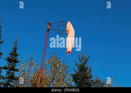 Ein Windsack hängt ruhig an einem blauen Himmel Stockfoto
