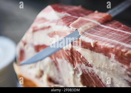 Der Küchenchef schneidet serrano-Schinken. Stockfoto