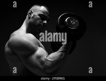 Portrait von muskulösen Männern, Bodybuilder trainieren, Heben Hantel, tun Übungen für Bizeps Blick auf sie Stockfoto