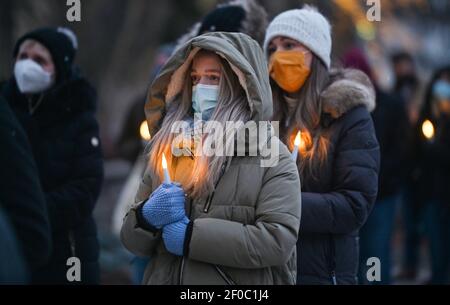 Wilkes Barre, Usa. März 2021, 06th. Freunde und Familie von Opfern halten brennende Kerzen, während der Veranstaltung. Außerhalb des Amtsgerichts Luzerne wurde im Rahmen des Projekts Gelbes Herz eine Gedenkfeier und Mahnwache für die Opfer von Covid19 abgehalten. Ein leerer Stuhl wurde aufgestellt, um jedes der in der Gemeinschaft verlorenen Leben darzustellen. Kredit: SOPA Images Limited/Alamy Live Nachrichten Stockfoto