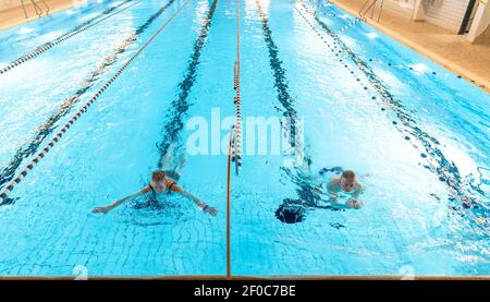 Schneverdingen, Deutschland. März 2021, 06th. Rosie (l) und Manfred Warnke schwimmen im Hallenbad Heidjers wohl. In der Corona-Sperre sind die Hallenbäder eigentlich geschlossen. In der Lüneburger Heide hat jedoch ein Betreiber eine Lösung gefunden, die es den Gästen ohnehin erlaubt zu schwimmen. Quelle: Philipp Schulze/dpa/Alamy Live News Stockfoto