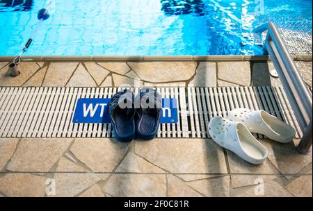 Schneverdingen, Deutschland. März 2021, 06th. Badeslipper stehen am Rande des Schwimmbades im Hallenbad Heidjers wohl. In der Corona-Sperre sind die Hallenbäder eigentlich geschlossen. In der Lüneburger Heide hat jedoch ein Betreiber eine Lösung gefunden, die es den Gästen ohnehin erlaubt zu schwimmen. Quelle: Philipp Schulze/dpa/Alamy Live News Stockfoto