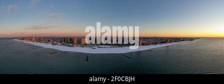 Luftaufnahme eines schneebedeckten Coney Island Beach während des Winters bei Sonnenaufgang in Brooklyn, New York. Stockfoto