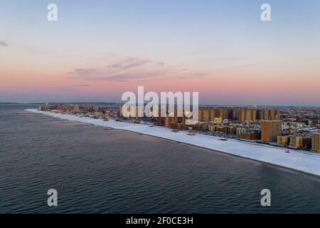 Luftaufnahme eines schneebedeckten Coney Island Beach während des Winters bei Sonnenaufgang in Brooklyn, New York. Stockfoto