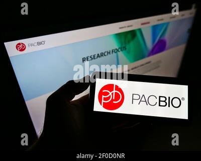 Person, die Smartphone mit Logo der US-Firma Pacific Biosciences of California Inc. Auf dem Bildschirm vor der Website hält. Konzentrieren Sie sich auf die Telefonanzeige. Stockfoto