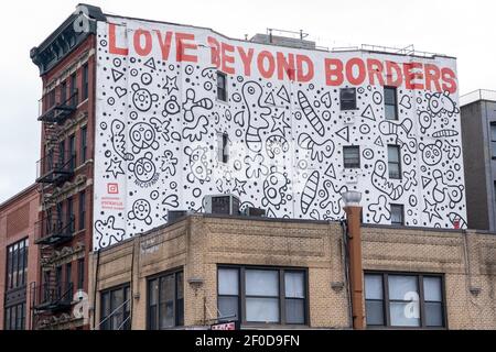 NEW YORK, NY – MÄRZ 6: Gebäude an der Allen Street in der Lower East Side mit einem Gemälde mit der Aufschrift "Love Beyond Borders", das während eines Protestes von Liox Cleaners vor einem Standort an der Lower East Side am 6. März zu sehen war, 2021 in New York City steht die Liox Cleaners-Kette im Gefolge des angeblichen "Gewerkschaftsbundes" vor einer Menge Opposition. Laut der verteilten Literatur, "am 19. Februar, die Liox-Wäscherei-Kette entlassen die eingewanderten Arbeiterinnen der Wash Supply Waschsalon. Kredit: Ron Adar/Alamy Live Nachrichten Stockfoto