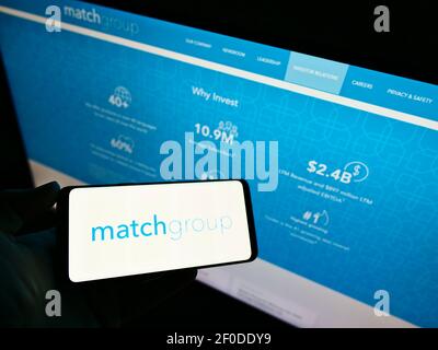Person mit Smartphone mit Logo der US-Online-Dating-Firma Match Group Inc. Auf dem Bildschirm vor der Website. Konzentrieren Sie sich auf die Telefonanzeige. Stockfoto