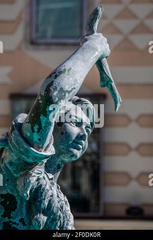 Nahaufnahme einer Statue mit einem sehr schönen Gesichtsausdruck, hält einen Fisch in der Hand Stockfoto