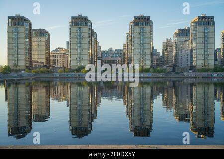 Neue Wohnblöcke am Fluss Smolenka, der Insel Vasilievskiy, St. Petersburg, Russland, spiegeln sich im Wasser wider Stockfoto
