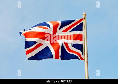 Winkende Flagge am blauen Himmel britische Farbe und Welle Stockfoto